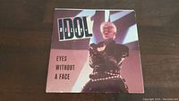 Front cover of Billy Idol 'Eyes Without A Face' 45rpm vinyl single showing image of Billy Idol and title text.