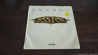 Front of the white paper sleeve featuring the Boston band logo and song title 'Amanda' with 45 rpm sticker.