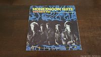 Front cover of the 45rpm vinyl single of 'What Does It Take' by Honeymoon Suite showing band members and artwork.