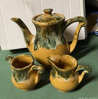 Vintage Beauceware ceramic teapot, creamer, and sugar bowl set showing glaze and shape.