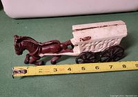 Side view of the vintage brown horse and white horse-drawn ice wagon with a tape measure showing length of about 7 inches.