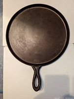 Top side view of the 12-inch cast iron crepe pan showing cooking surface and handle.