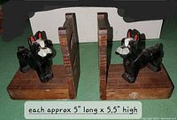 Photo of pair of wooden Boston Terrier bookends from side angle showing dog figures and wooden base and backing, with size approximately 5 x 5.5 inches noted in image.