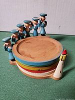 Stacked coasters with sailor figurines and lighthouse on side showing custom painted rims and wood grain