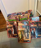 Photo showing six total action figures from Teenage Mutant Ninja Turtles and Robin Hood series in original packaging.