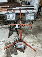 Full view of the lot showing two Craftsman dual-head tripod work lights and two single-head Utilitech portable work lights positioned on the floor.