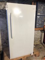 Front view of the white upright freezer showing the door and vertical handle.