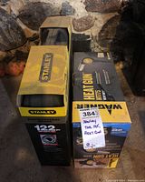 Photo of Stanley 122-piece tool set box next to Wagner heat gun box showing lot items in packaging.