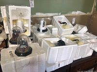 Multiple Star Trek globes in clear domes on black bases with foam packing around them