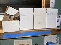 Four white cardboard boxes labeled for trading cards on shelf; three labeled for Comic Ball 2, one for Star Trek cards