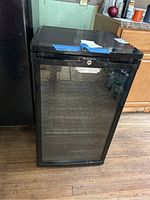 Frigidaire wine refrigerator front view showing glass door and black exterior.