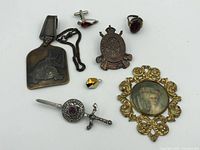 Full lot layout showing all vintage pins, brooch, ring, cufflink, pendant, and belt clip.