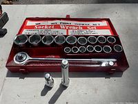 Front view of the 21-piece socket wrench set including sockets, ratchet, extension bar, joint, and metal case on a white surface.