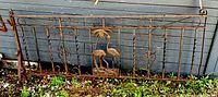 Full view of the iron fence piece showing the flamingo and palm tree design, overall condition and size.