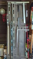 Full view of all measuring tools including levels, wooden yardstick, T-square, and angle devices.