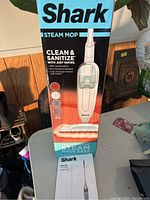 Box of Shark Steam Mop showing the product image, brand and key features like cleaning and sanitizing with just water.