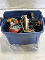 Blue storage box packed with hand and power tools seen from above