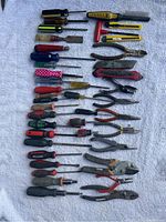 Overview of all 40 hand tools spread out on a flat surface showing diversity of tool types and colors.