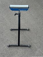 Front view of the Mastercraft roller stand showing the metal roller, adjustable black metal frame, and base support with rubber feet.