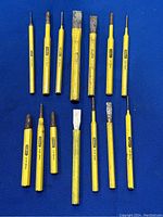 All 14 punches and chisels laid out on blue background showing varying tip types and sizes.