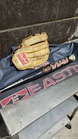 Rawlings baseball glove on top of blue Easton sports bag with Louisville Slugger TPS baseball bat