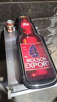 Front view of Molson Export neon beer bottle-shaped bar sign showing branding and design details.