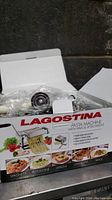 Box of Lagostina pasta machine showing product name and images of different pasta types made by the machine.