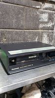 Front view of the black Panasonic VHS player showing the VHS tape slot and Panasonic branding.