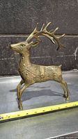 Front side close-up of the solid brass reindeer figurine showing detailed antlers and textured body.