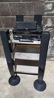 Overall view of the Yamaha audio system with 5 speakers and receiver on a small metal shelf. Floor standing speakers in front, smaller speakers behind the receiver.