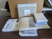 Overall view of six packages of new bedding sheets and pillowcases from various brands including Nautica, Wellness and Classic.