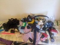 Photo showing a pile of assorted sewing notions including zippers, buttons, elastics, and cords on a table.