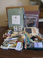 Wide view showing most of the sewing notions, vacuum attachments, blanket and pattern all arranged on a table