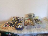 Wide shot showing multiple baskets and plastic bins filled with spools of thread and other sewing accessories on a covered table.