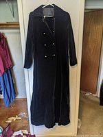 Full length view of navy blue velvet double-breasted maxi coat showing front, buttons, collar, and sleeves.