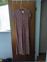 Full view of the vintage Diane Deckel tea gown hanging on a door, showing overall length and design.