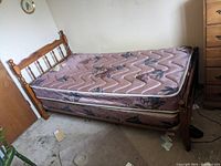 Vintage wooden twin bed frame with floral pink mattress and boxspring in used condition.