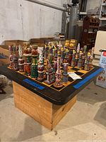 Full view of the handmade wooden chess set on wooden crate, showing the chessboard and all chess pieces arranged for display.