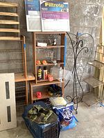 Shows shelving unit with Filtrete 1500 air filters, orange parking marker balls, donation box, various cans, gloves, cat litter bag, and pet crate under the shelves