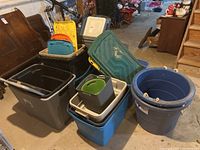 Photo showing an assortment of plastic storage totes of different colors and sizes stacked together, including lids in yellow, turquoise, gray, and orange.