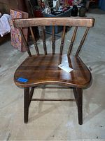 Front view of the vintage wooden low back chair showing overall shape, wood grain, and condition with scratches.