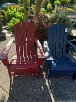 Front view of red and blue poly wood Adirondack chairs on patio surface
