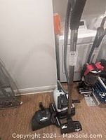 Front view of vacuum assembled with wand and floorhead on hardwood floor