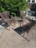 Overview of two chairs, loveseat and round table on patio surface