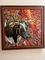 Frontal view of entire painting and frame showing a bull portrait with floral background