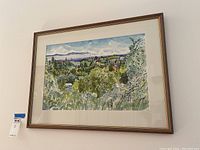 Framed watercolor painting hanging on the wall, showing the beach town landscape in full view.