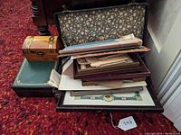 Open valise filled with assorted vintage photographs, framed and loose, ephemera, and documents.