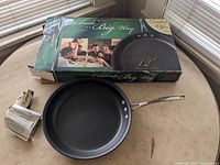 Calphalon 12-inch omelette pan with original box on a countertop, pan handle visible.