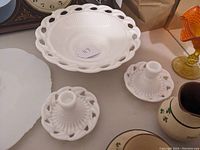 Photo showing two Wistar pattern candle holders alongside the console bowl, highlighting the pierced and ribbed milk glass design.