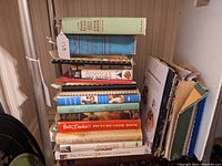 Stacked cookbooks displaying titles including 'The New Fannie Farmer Cookbook', 'Betty Crocker's Picture Cook Book', and America’s Test Kitchen.